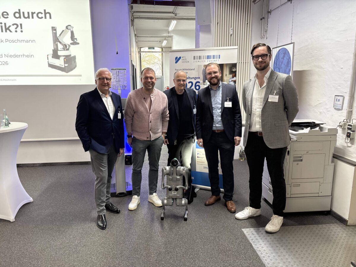 Gruppenbild mit Roboter-Hund: (v.l.) Moderator Prof. Dr. Thomas Merz, Willichs Bürgermeister Christian Pakusch, WFG-Geschäftsführer Dr. Thomas Jablonski, Prof. Dr. Hendrik Poschmann von der Hochschule Niederrhein und Unternehmer Steffen Mallon. Foto: WFG